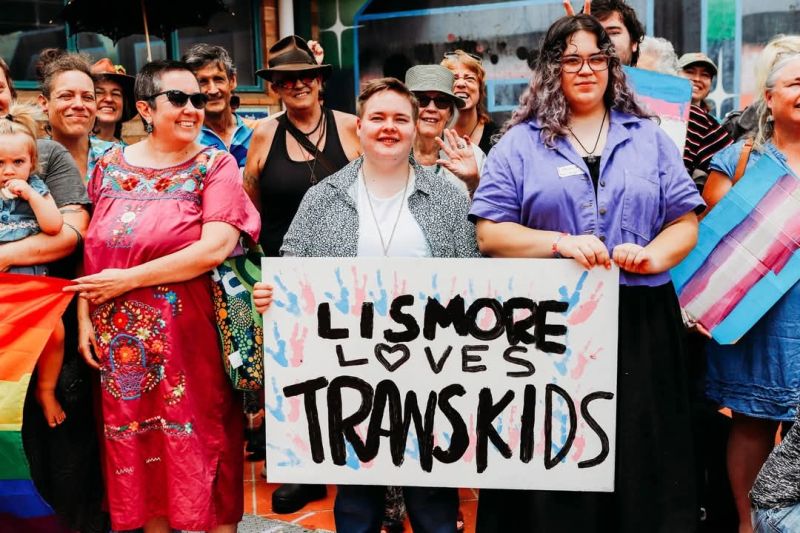 A group of people holding a banner saying 'Lismore Loves Trans Kids'